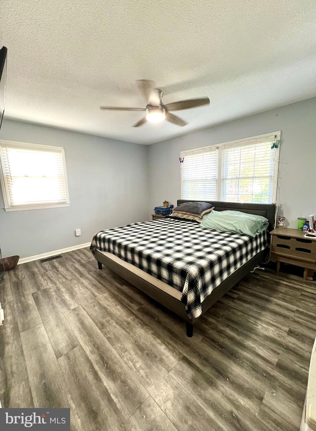 bedroom featuring wood-type flooring, a textured ceiling, and ceiling fan