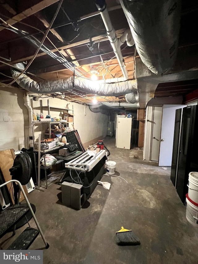 basement with white refrigerator and water heater