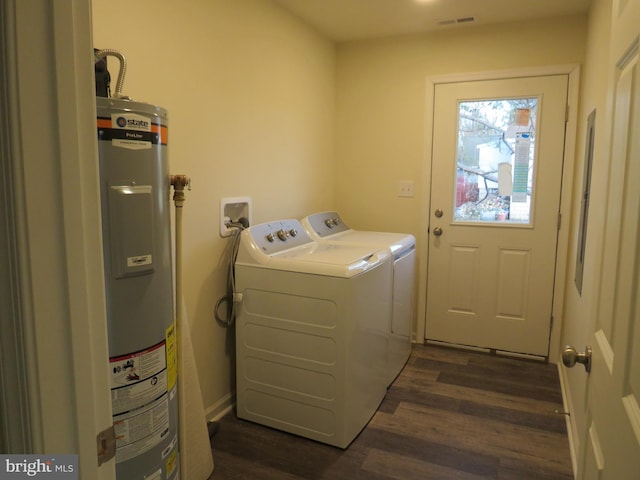 clothes washing area with independent washer and dryer, dark wood-type flooring, and water heater