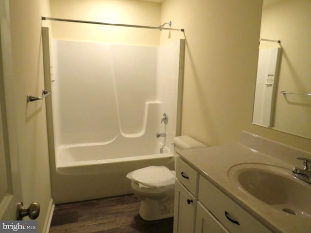 full bathroom with bathing tub / shower combination, vanity, wood-type flooring, and toilet