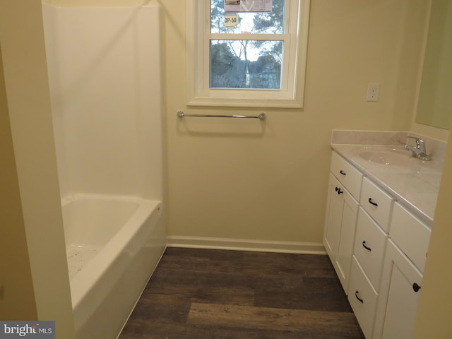 bathroom with hardwood / wood-style floors, vanity, and a bath