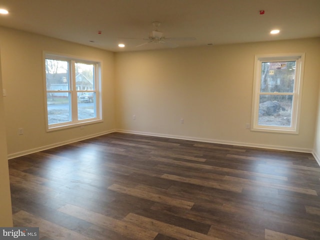 empty room with ceiling fan and dark hardwood / wood-style flooring