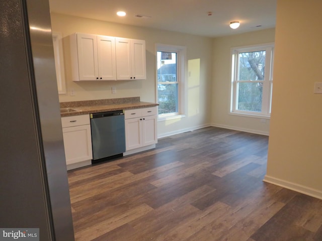 kitchen with stainless steel appliances, white cabinetry, and dark hardwood / wood-style floors