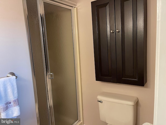 bathroom with a shower with door and toilet