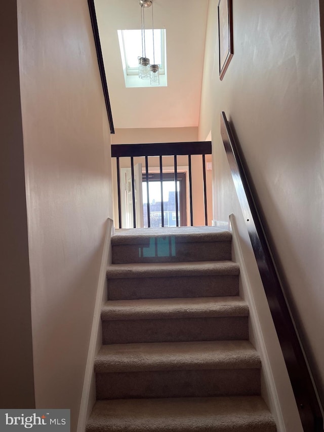 stairs featuring a notable chandelier