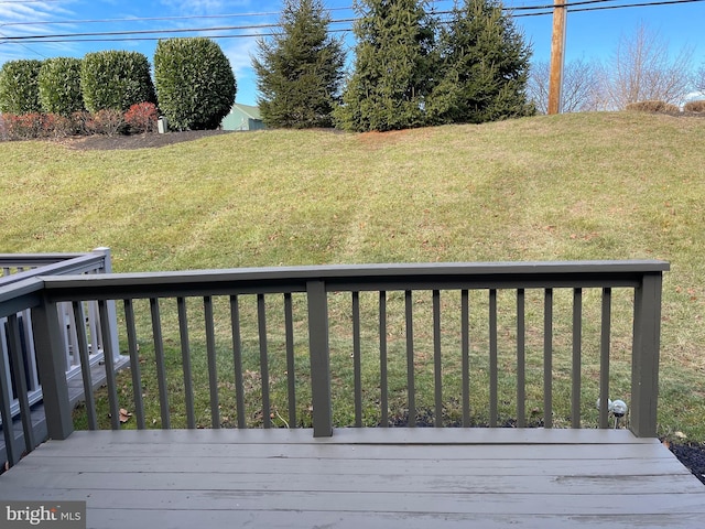 wooden deck featuring a lawn