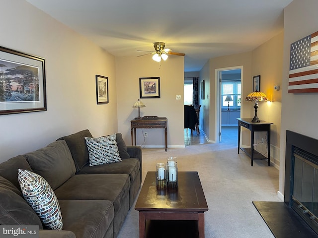 carpeted living room with ceiling fan