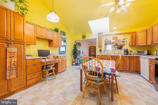 kitchen featuring white dishwasher, ceiling fan, sink, decorative light fixtures, and high vaulted ceiling