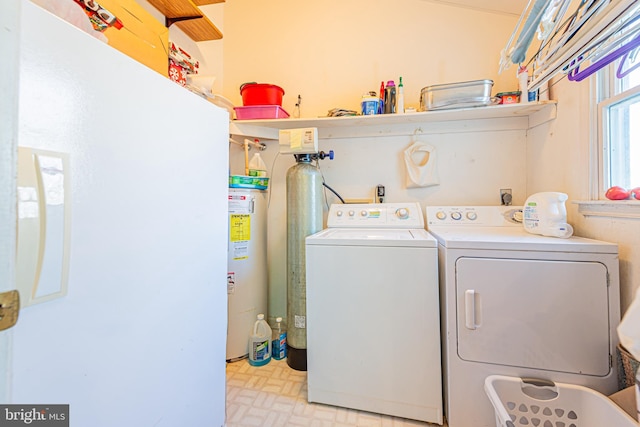 washroom with water heater and washing machine and clothes dryer