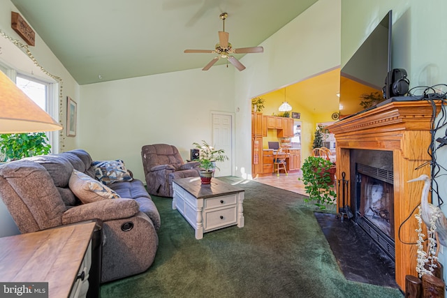 carpeted living room with ceiling fan and high vaulted ceiling