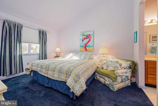 bedroom featuring vaulted ceiling and ensuite bath