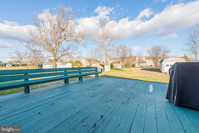 wooden terrace featuring a grill, a shed, and a yard