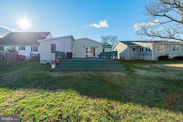 rear view of house featuring a lawn and a wooden deck