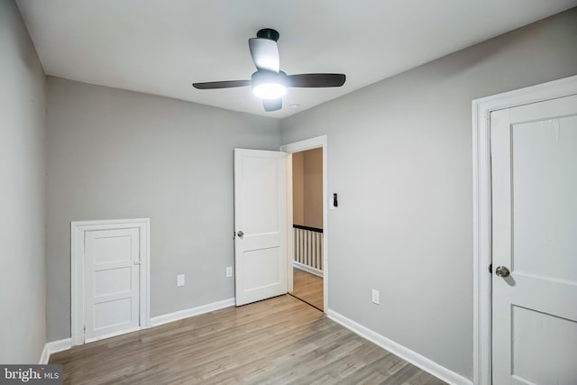 unfurnished bedroom with ceiling fan, a closet, and light hardwood / wood-style floors