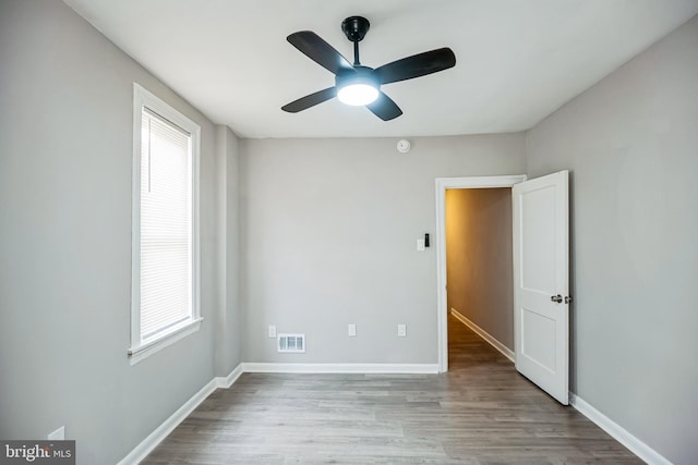 empty room with ceiling fan and light hardwood / wood-style floors