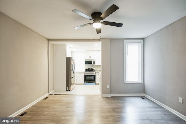 unfurnished living room with ceiling fan and light wood-type flooring