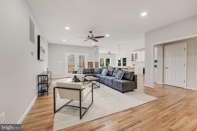 living room with light hardwood / wood-style flooring, french doors, and ceiling fan