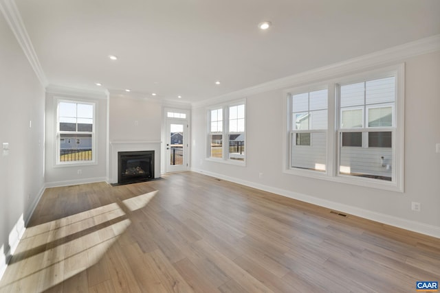 unfurnished living room featuring light hardwood / wood-style flooring and ornamental molding