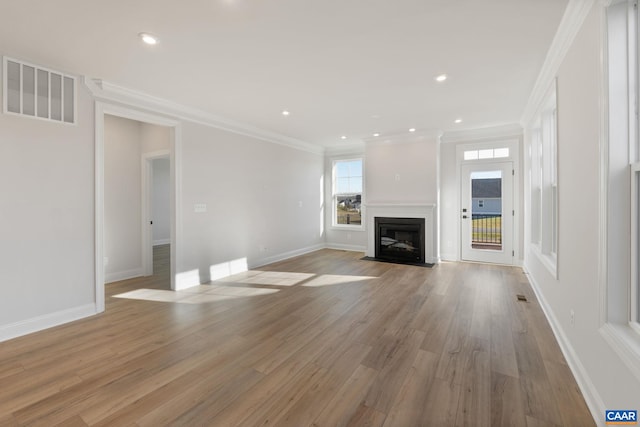 unfurnished living room featuring light hardwood / wood-style flooring and crown molding