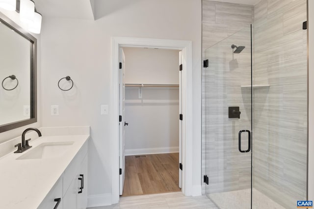 bathroom with vanity, wood-type flooring, and walk in shower