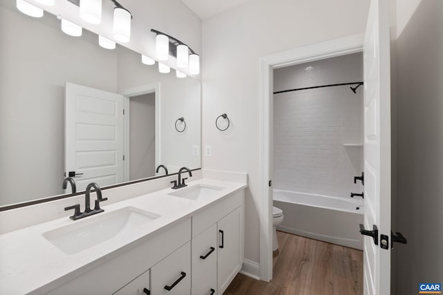 full bathroom with bathing tub / shower combination, hardwood / wood-style floors, vanity, and toilet