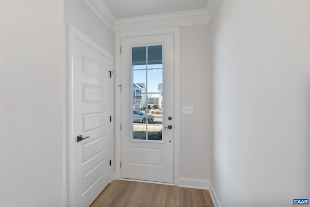 doorway featuring crown molding and light hardwood / wood-style flooring