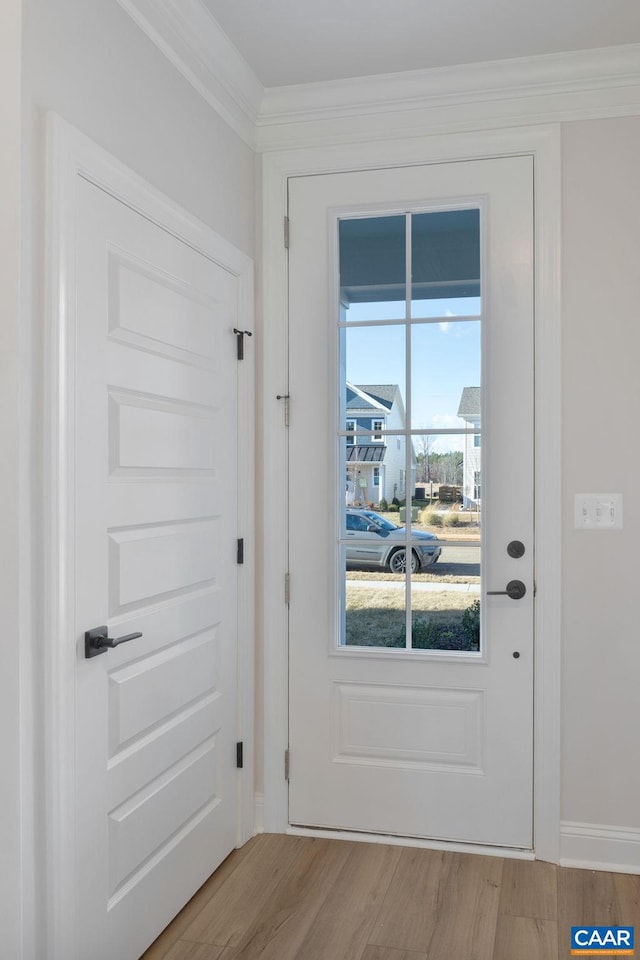 entryway with light hardwood / wood-style floors and ornamental molding