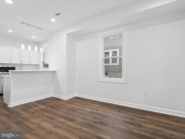 kitchen featuring kitchen peninsula, track lighting, white cabinets, dark hardwood / wood-style floors, and hanging light fixtures