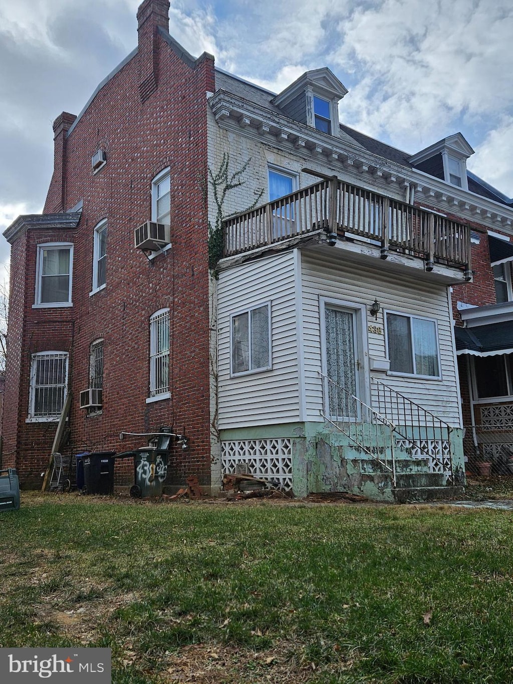 exterior space featuring a lawn, a balcony, and cooling unit