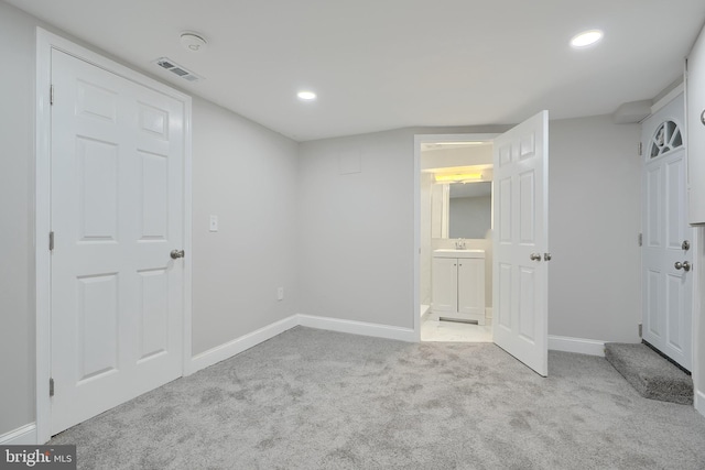 unfurnished bedroom featuring sink and light carpet