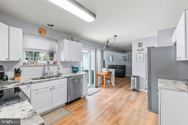 kitchen featuring white cabinets, stainless steel appliances, light wood-type flooring, and sink