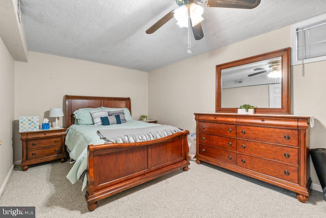 carpeted bedroom with ceiling fan and a textured ceiling