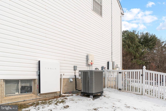 view of snowy exterior with central AC unit