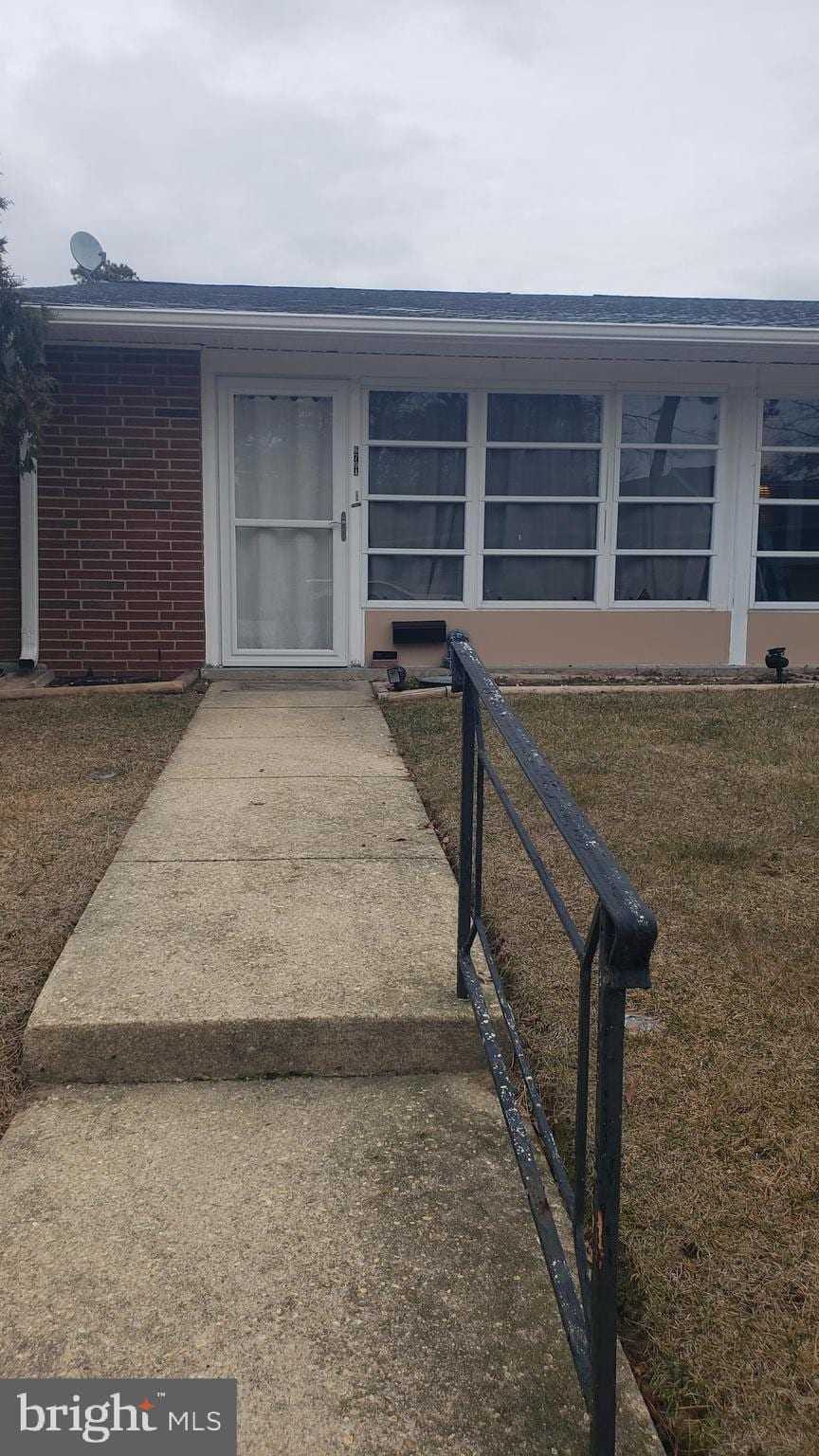 property entrance featuring a lawn