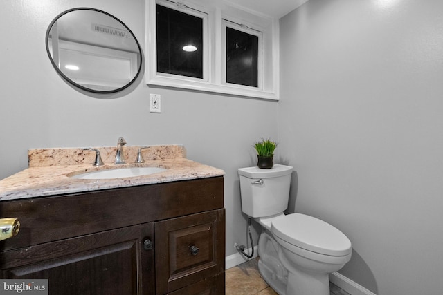 bathroom featuring tile patterned flooring, vanity, and toilet