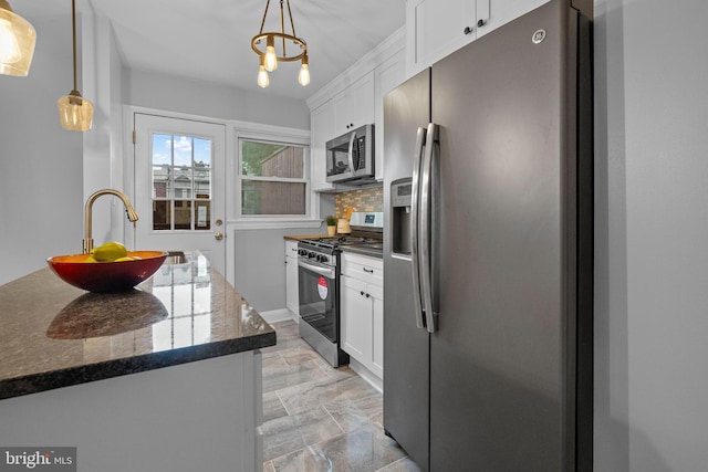 kitchen featuring white cabinets, decorative backsplash, stainless steel appliances, and pendant lighting