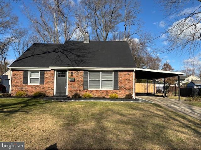 view of front of property featuring a chimney, a front lawn, an attached carport, and brick siding