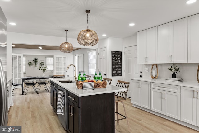 kitchen with light wood-type flooring, light countertops, and a sink