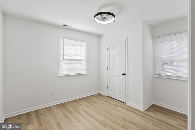 unfurnished bedroom featuring light wood finished floors, baseboards, and visible vents