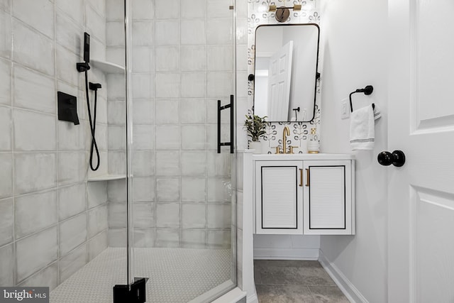 full bath with a stall shower, baseboards, and vanity