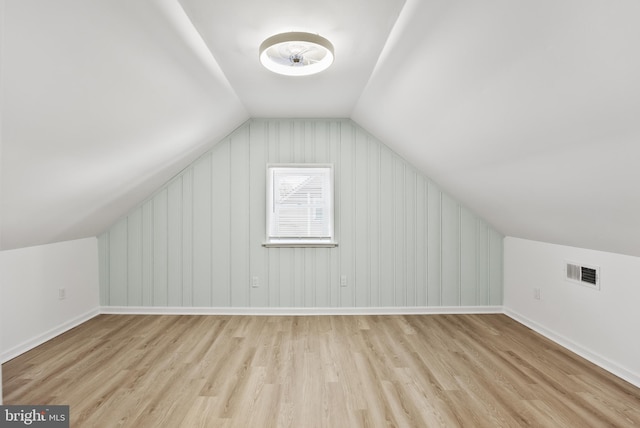 bonus room with lofted ceiling, baseboards, visible vents, and wood finished floors