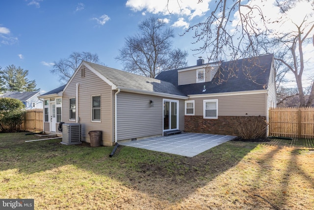 back of house with a lawn, a patio, a chimney, fence, and central air condition unit