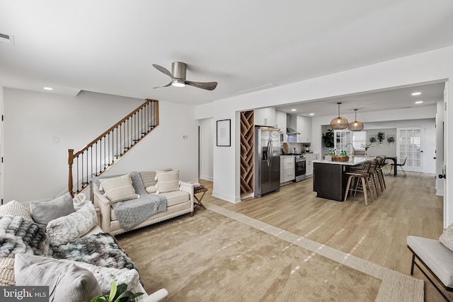 living room featuring light hardwood / wood-style floors and ceiling fan