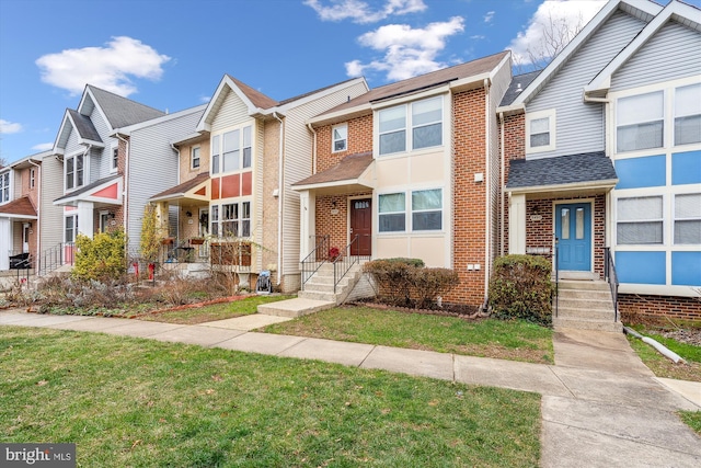 townhome / multi-family property featuring a front lawn