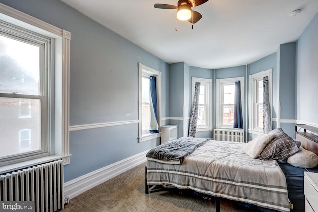 bedroom featuring radiator, ceiling fan, carpet, and multiple windows