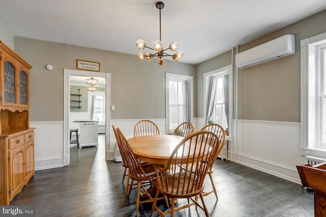 dining room featuring dark hardwood / wood-style flooring, a wall unit AC, and a notable chandelier