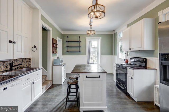 kitchen with sink, decorative light fixtures, dishwasher, black electric range, and a center island