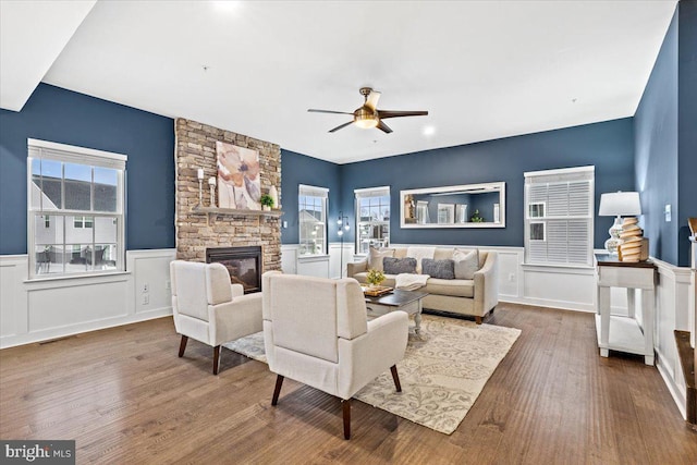 living room with ceiling fan, wood-type flooring, and a fireplace