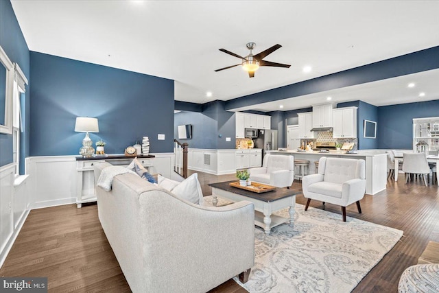 living room with ceiling fan and dark wood-type flooring