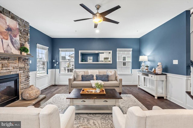 living room with a fireplace, ceiling fan, and dark hardwood / wood-style flooring